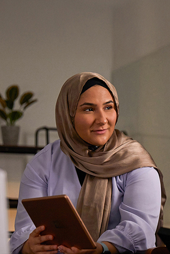إحدى أعضاء فريق التعلم الآلي والذكاء الاصطناعي في Apple تحمل جهاز iPad.