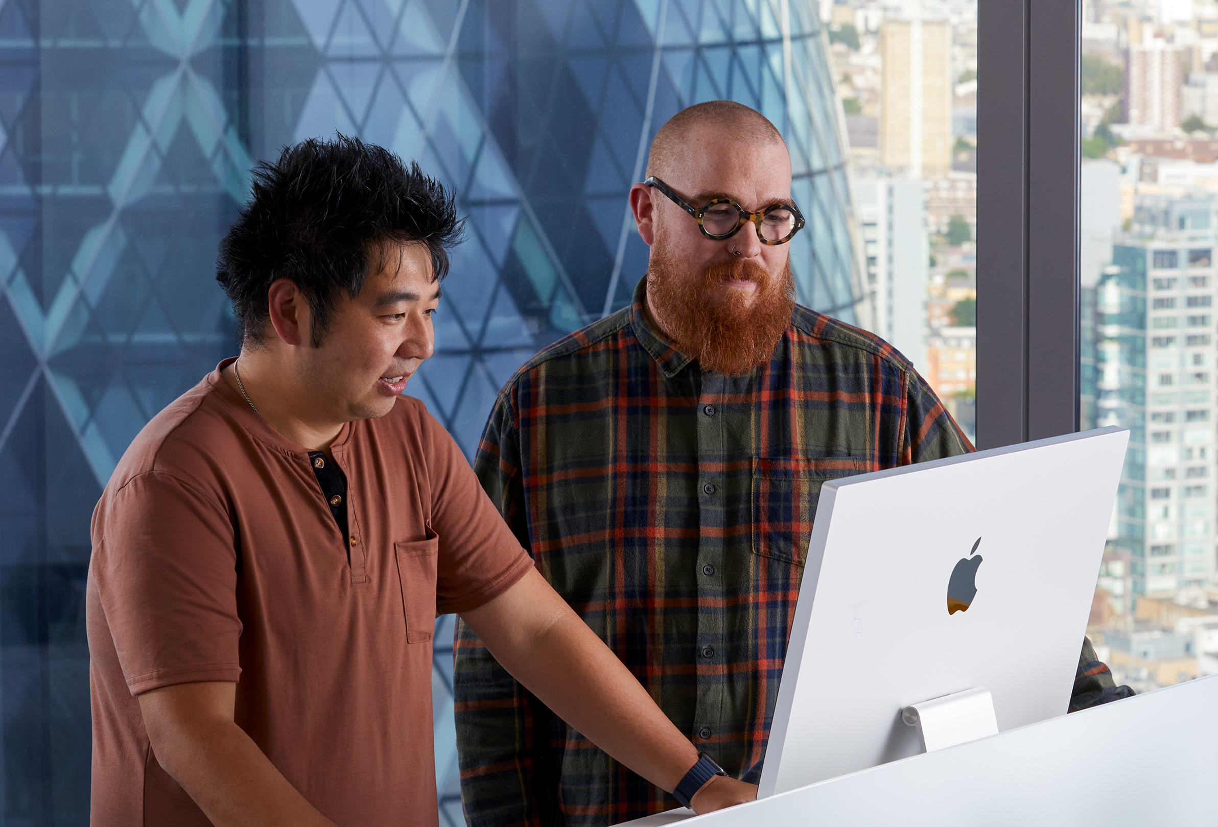 2人のApple社員がアイマックを使って共同作業をしている。