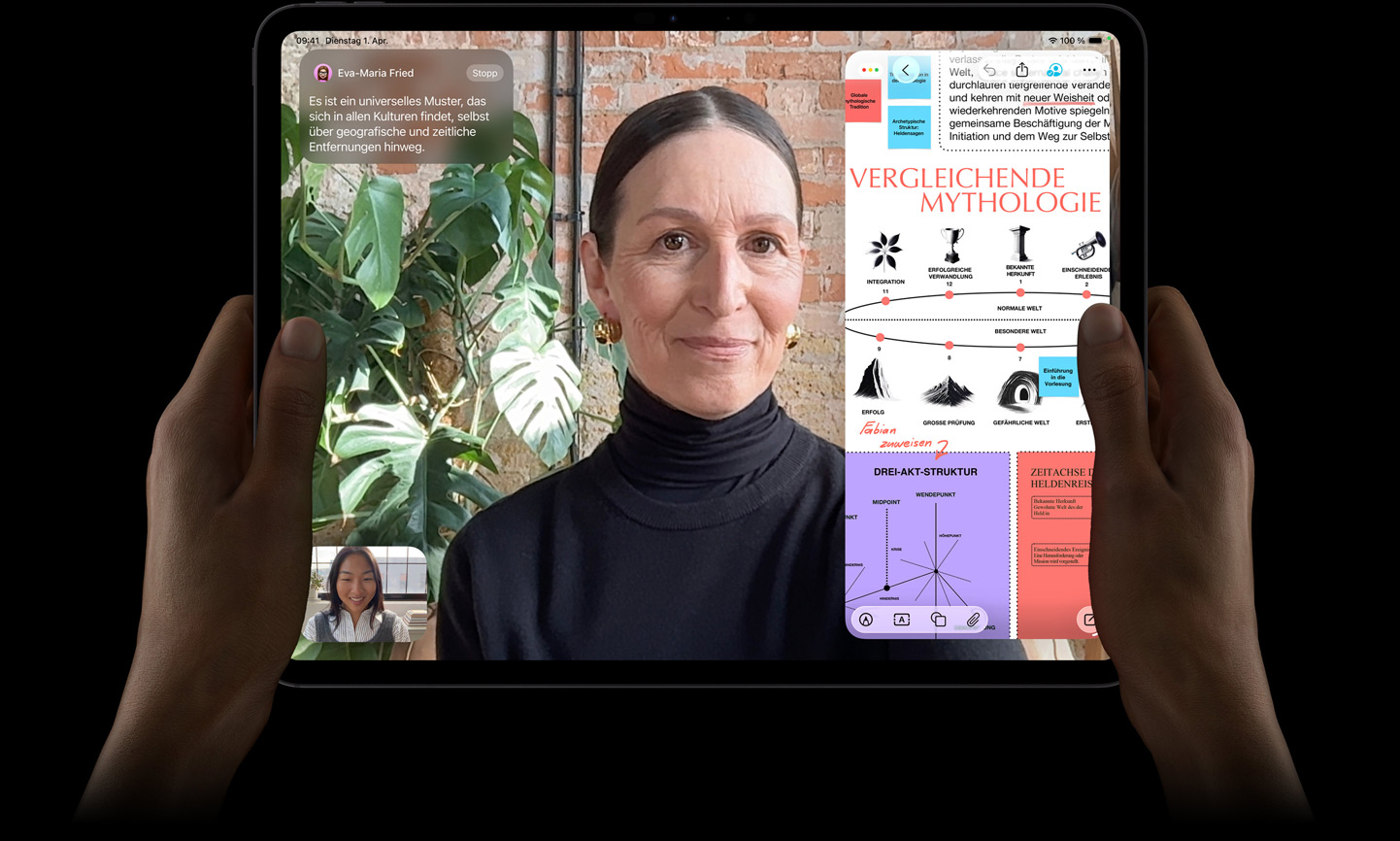 iPad Pro, Vorderansicht, Farbe Space Schwarz, linke und rechte Hand halten es im Querformat, gerundete Ecken, schwarzer Displayrand, das Display zeigt ein FaceTime Gespräch, das live übersetzt wird, und eine Lernapp zeigt eine Präsentation zu „Vergleichende Mythologie“ mit Text, Diagrammen und handschriftlichen Notizen