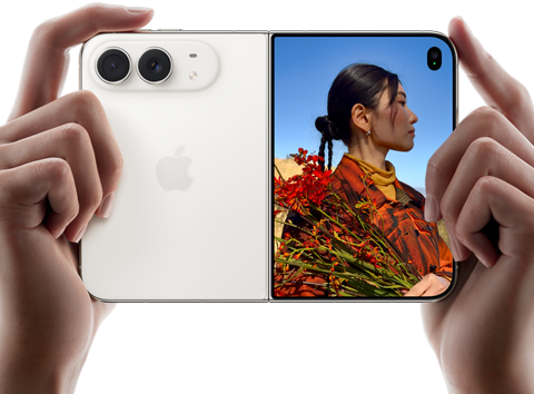 iPhone Duo, σε Λευκό του Άστρου, κρατιέται από δύο χέρια σε οριζόντιο προσανατολισμό, ξεδιπλωμένο, το αριστερό πλαίσιο δείχνει τις πίσω κάμερες Dual Fusion 48 MP, το δεξί πλαίσιο δείχνει ένα άτομο που το τραβούν φωτογραφία σε μια εξωτερική οθόνη, το άτομο μπορεί να δει το πρόσωπό του καθώς το τραβούν φωτογραφία με τη λειτουργία Duo Preview