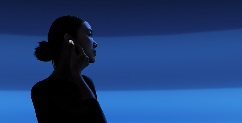 Asmuo nykščiu ir rodomuoju pirštu laiko „AirPods 5“ kotelį, kad pakeistų klausymosi režimus