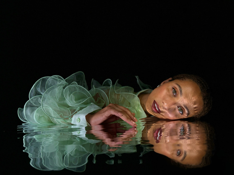 A person and their reflection captured using the 48MP Main camera with the new 24MP super- high-resolution default on iPhone 15 Pro.