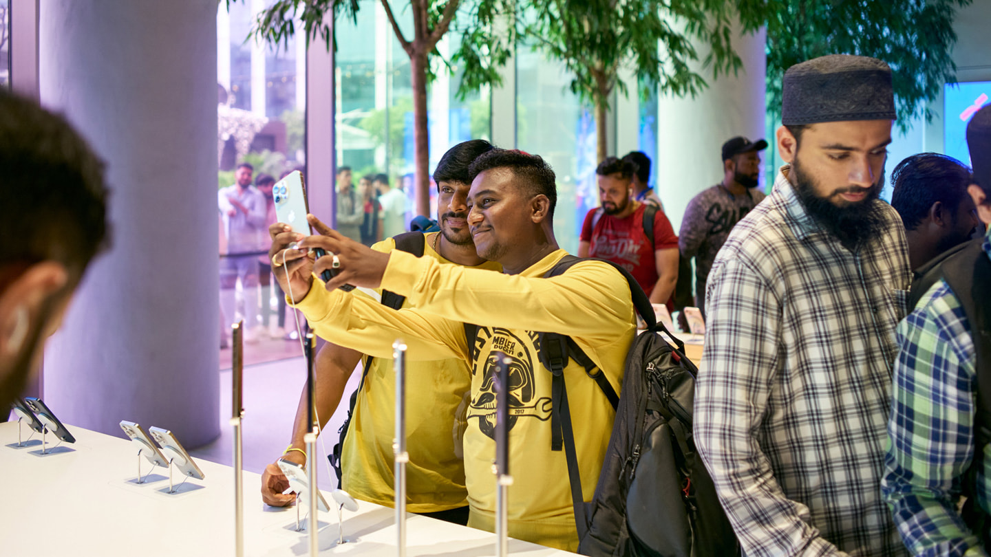 Two customers take a selfie with the new iPhone 15 Pro at Apple BKC in Mumbai.