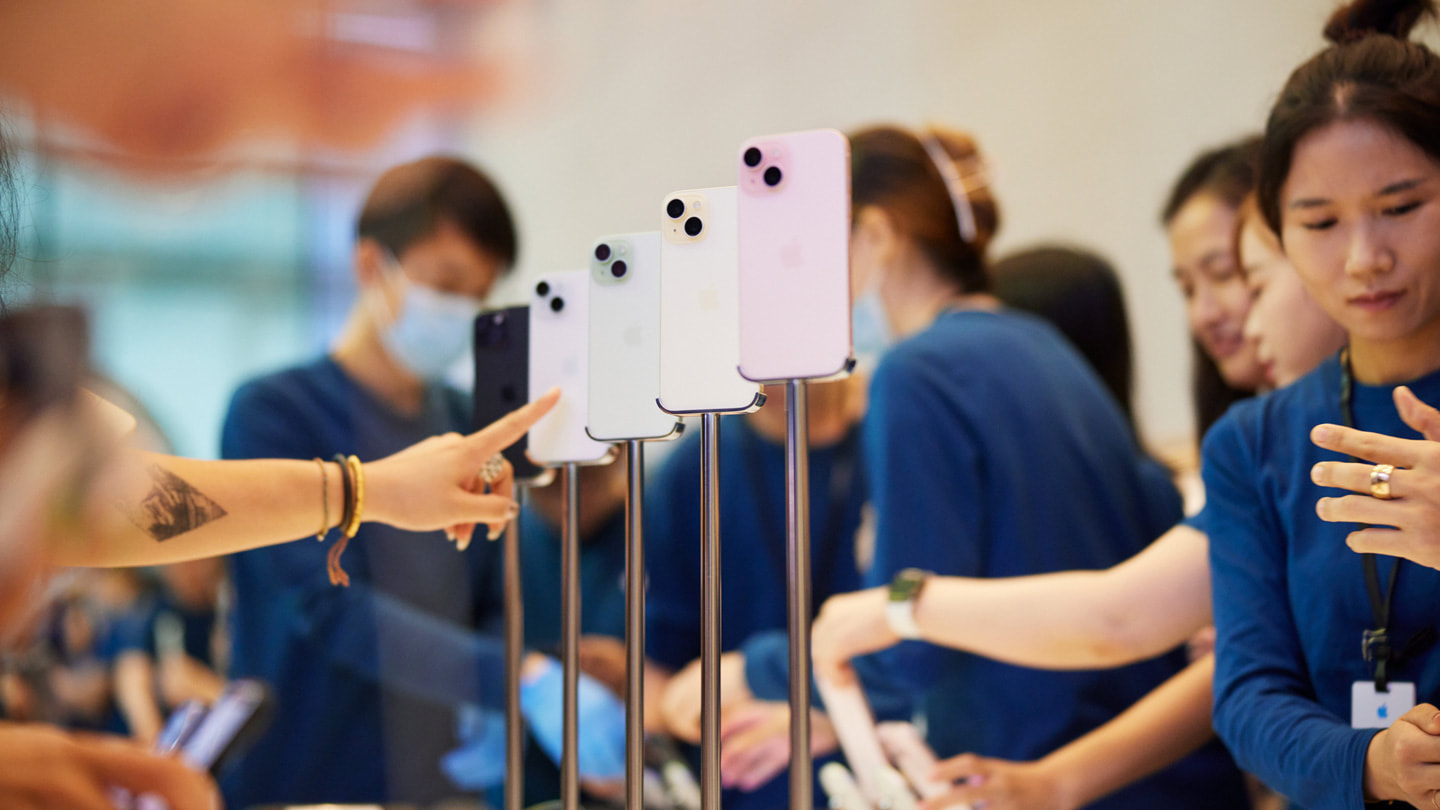 The iPhone 15 display table showcasing the full color lineup: black, blue, green, yellow, and pink.