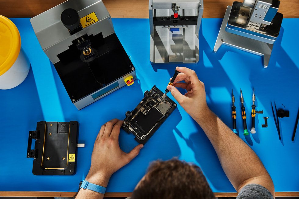 An overhead shot of a person performing Self Service Repair on an iPhone.