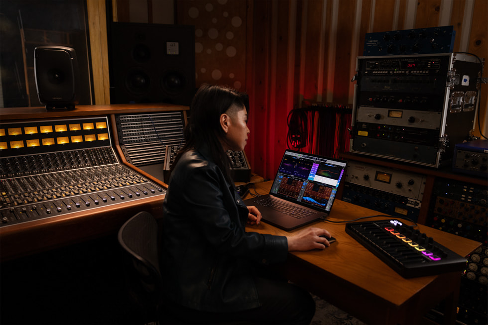 A Logic Pro user is shown working on MacBook Pro in a music studio.