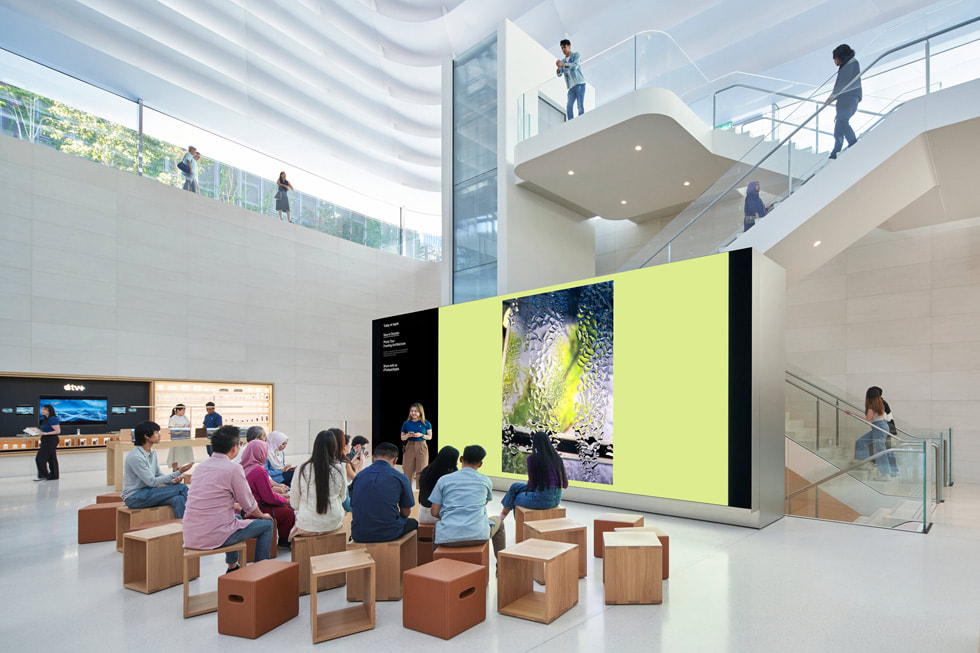 Customers sit in front of the store’s video wall.