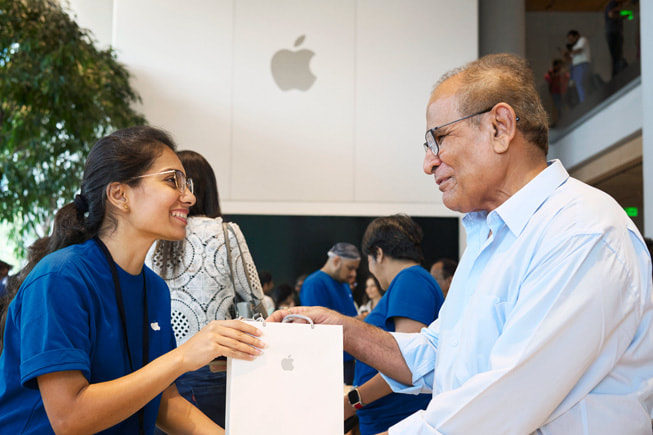 Osoba z zespołu Apple wspiera obsługiwaną osobę podczas zakupu.