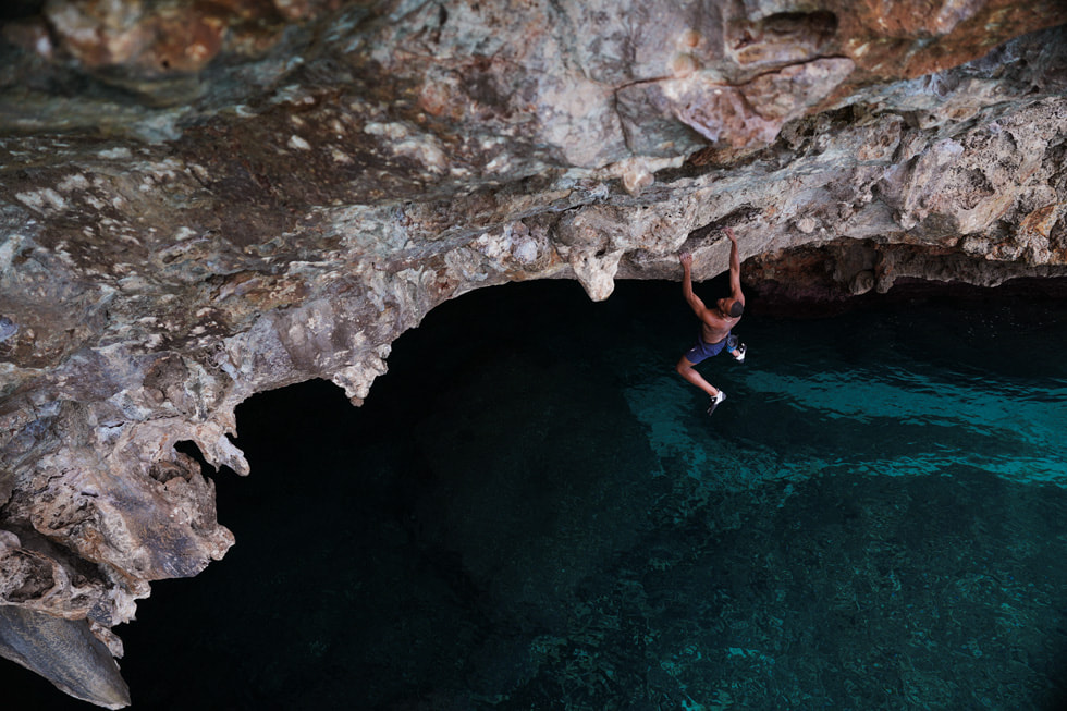 Kai Lightner suspendu à une falaise au-dessus de la mer dans l’épisode « Free Solo » de la série Adventure.