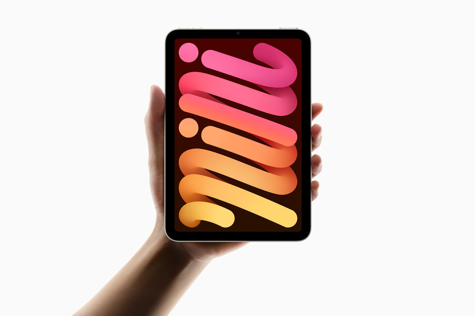 A hand holds up the new iPad mini.