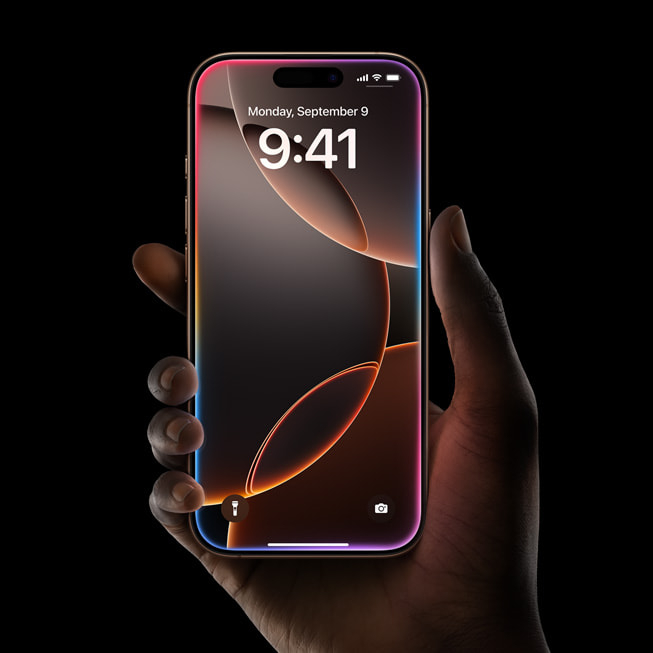 The glow from Apple Intelligence-powered Siri is shown on a user’s iPhone 16 Pro.