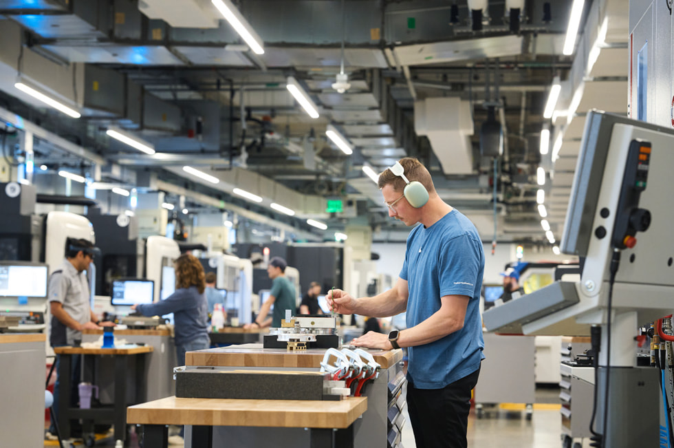 A worker in headphones examines a piece of material at Apple’s second campus in Austin.