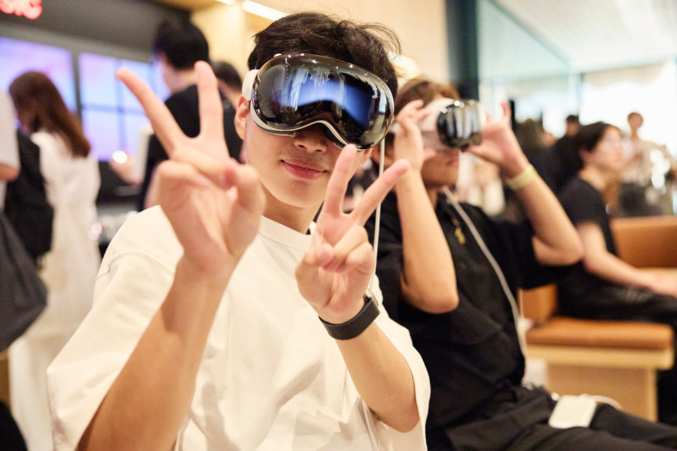 Customers are shown wearing Apple Vision Pro at Apple Ginza.