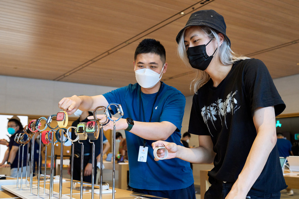 An Apple Sanlitun team member showing a customer Apple Watch devices.