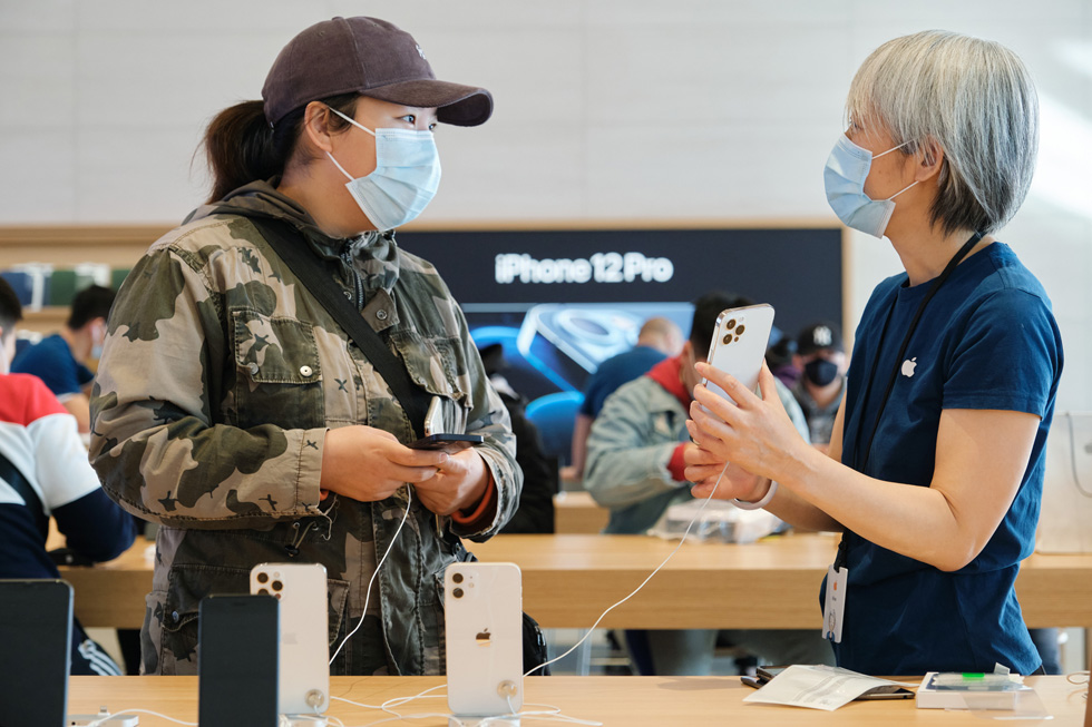 An Apple Sanlitun team member answers a customer’s questions about iPhone 12 Pro Max.