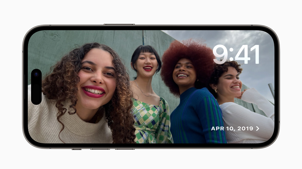  تُظهر تجربة وضع الاستعداد في نظام iOS 17 على iPhone 14 Pro مجموعة من الأصدقاء وهم يلتقطون صورة معاً.