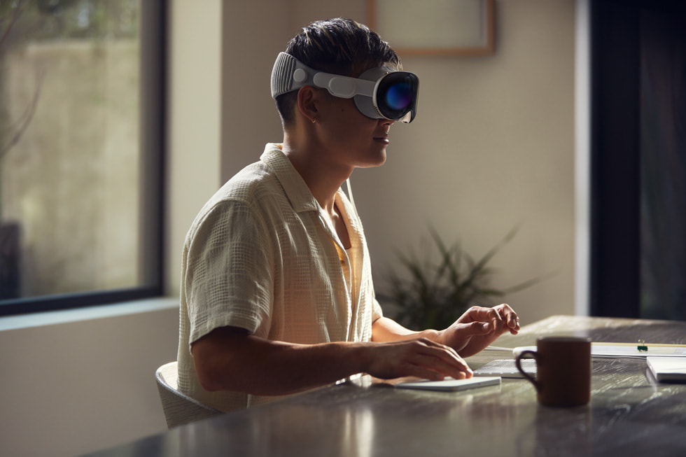 Una persona trabaja con Apple Vision Pro y su computadora.