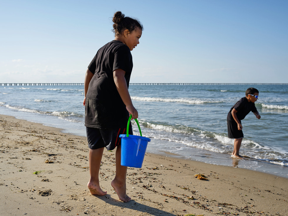 Jay (front) stands at the shoreline of Virginia Beach with his twin brother Nick.