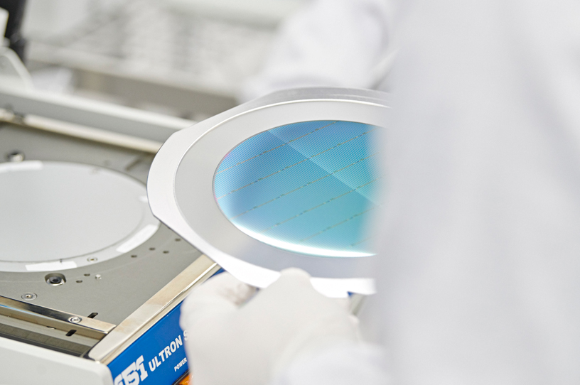 A Finisar technician handles a VCSEL wafer during production.