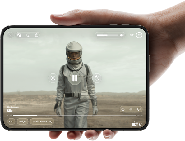 iPhone Duo v jednej ruke, otvorený na šírku, úplne rozložený, na vnútornom displeji sa zobrazuje seriál Apple TV s názvom Silo