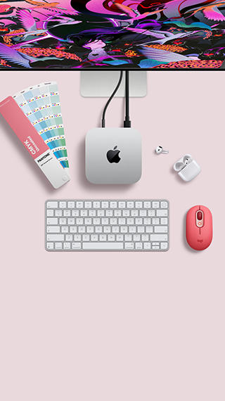 Mac mini, вид зверху, алюмінієвий корпус сріблястого кольору, заокруглені кути, глянцевий чорний логотип Apple по центру, підʼєднання за допомогою кабелю, Studio Display частково видно зверху, AirPods 4, відкриті, зразки кольорів Pantone, цифрова клавіатура та миша