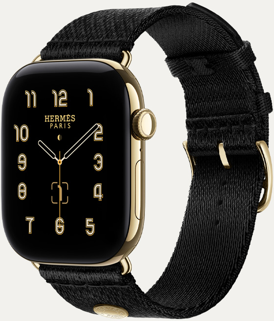 ساعة Apple Watch Hermès Series 12، واجهة الساعة بعقارب Clou de Selle (عقارب الساعة والدقيقة والثانية، الإضافات: الطور القمري، التاريخ)، إطار تيتانيوم، لون ذهبي ساطع، الجهة الخارجية اليمنى، التاج الرقمي، زر جانبي، مقترنة بحزام Satin Clou de Selle بلون Noir، نسيج حريري أسود سلس مع أجزاء بلون ذهبي ساطع تتطابق مع إطار الساعة