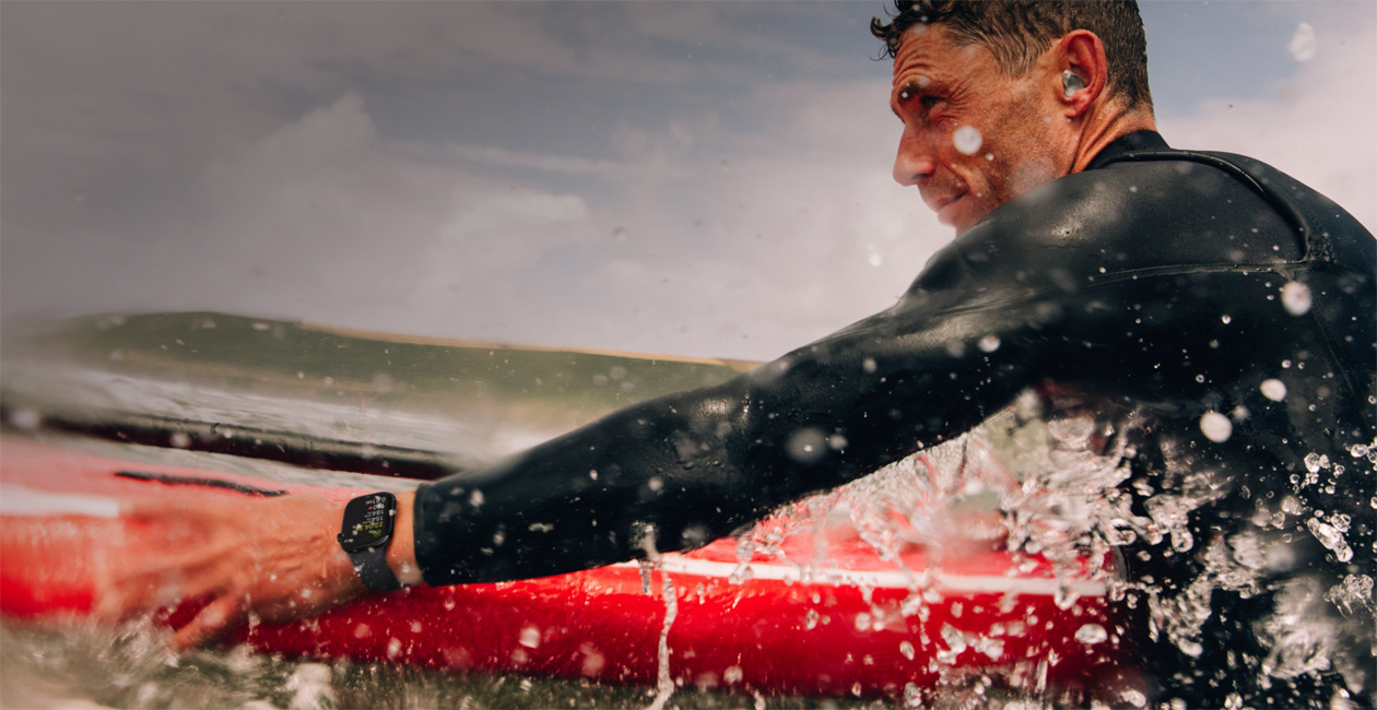 Un homme surfe avec une Apple Watch au poignet.
