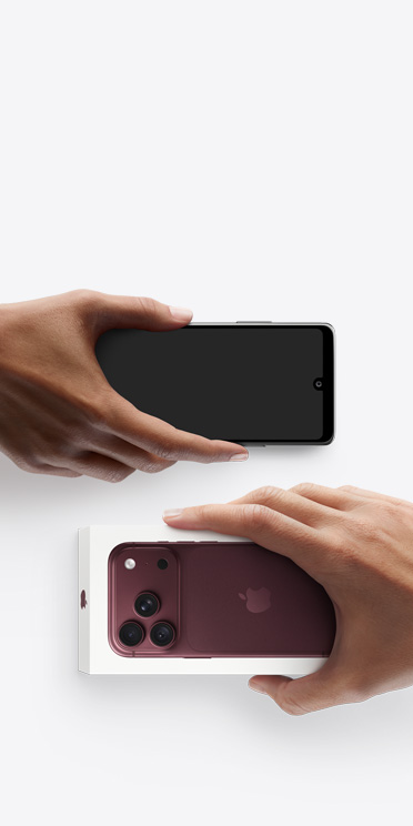 يدان تتبادلان هاتفين، هاتف Android على اليسار من دون علبة، وعلى اليمين iPhone 18 Pro جديد، لون عنّابي (أحمر داكن)، في علبته