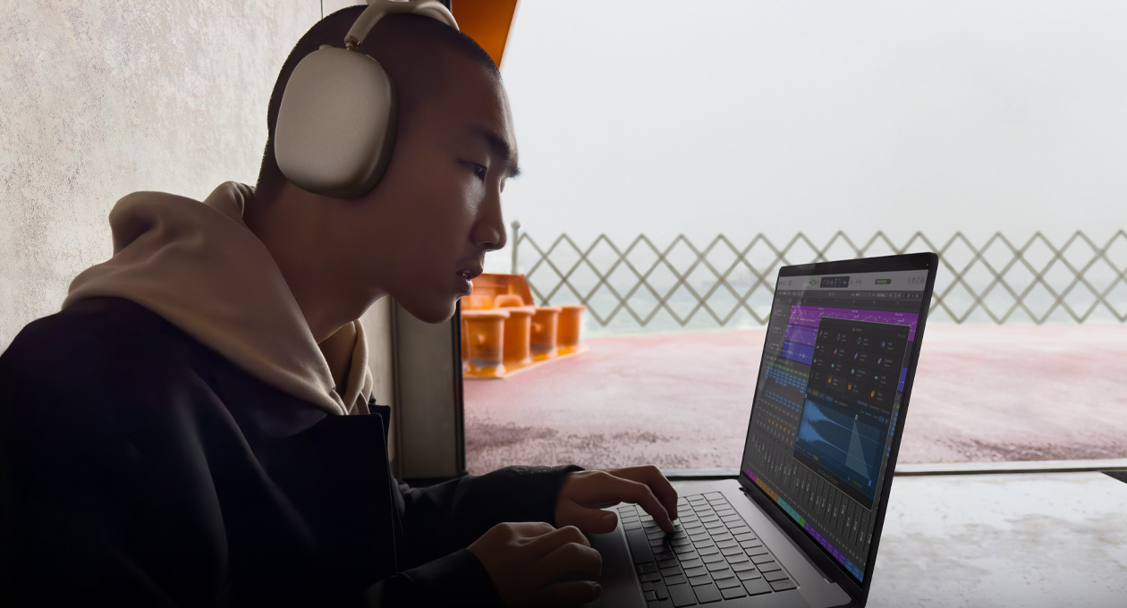 Side profile of a person wearing AirPods Max using Logic Pro on a MacBook Pro 16
