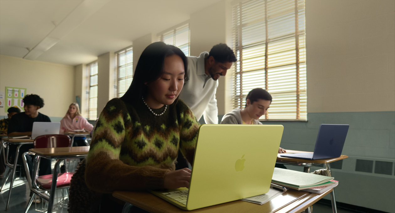 Bir öğrenci MacBook Neo kullanıyor, puslu sarı renk, sınıf ortamı, MacBook Neo şarja takılı değil