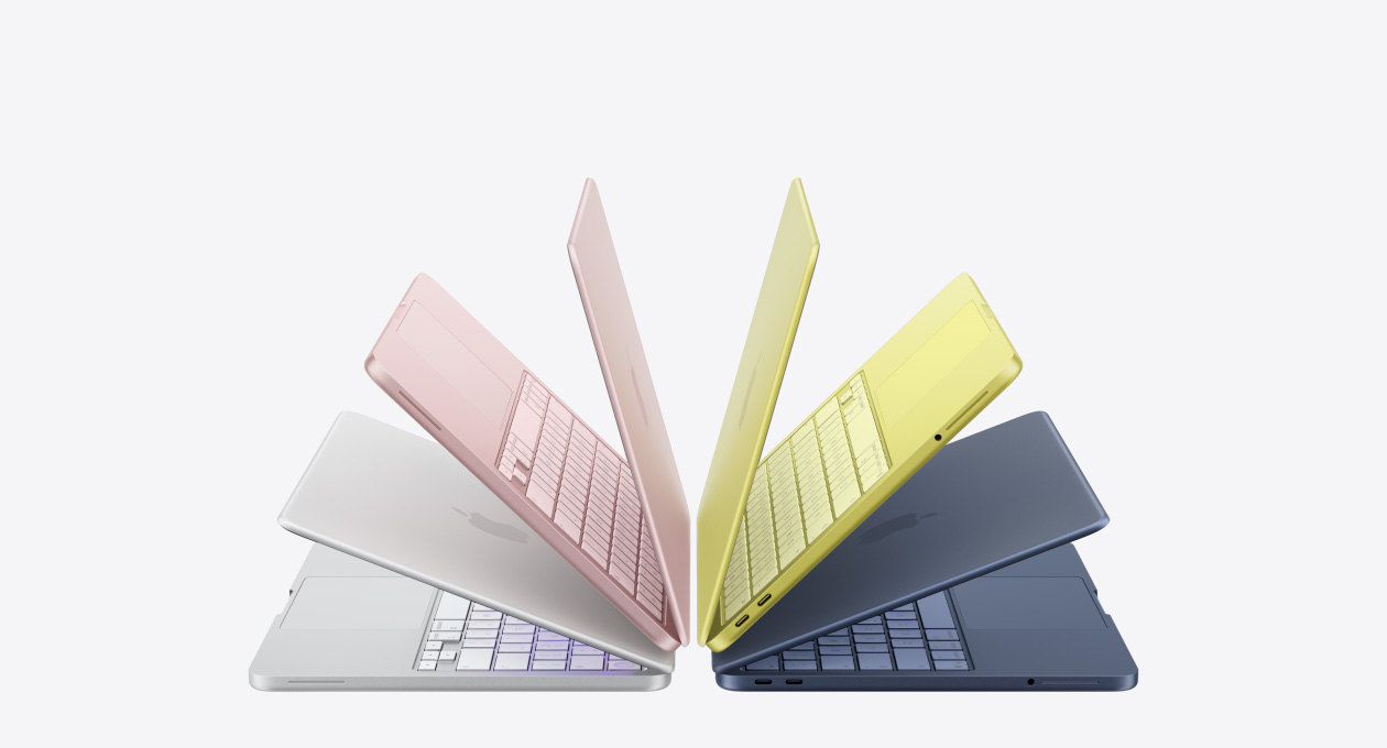 Gümüş, pastel pembe, puslu sarı ve Indigo renklerinde, hafifçe açık duran ve yay biçiminde dizilmiş MacBook Neo laptoplar