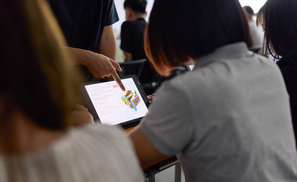 Bir kişi sınıf ortamında bir tablet ekranındaki obje hakkında geri bildirimini paylaşıyor